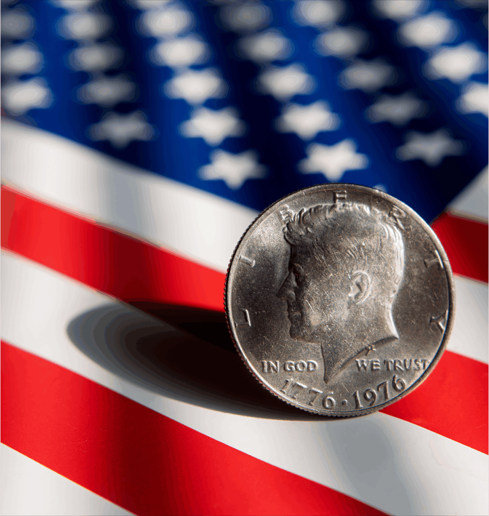 Coin on top of a American flag with light shining on top of it.